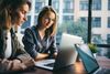 Two female colleagues looking at a laptop