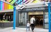 An adult and child walk hand in hand inside Great Ormond Street Hospital for Children.
