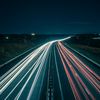 Time-lapse photo of cars on a highway at night.