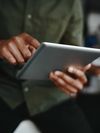 Person wearing military fatigues uses laptop computer.