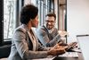 smiling man and woman in office discuss work
