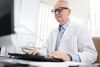 Doctor working on computer with medical records