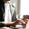 A person enters their information on a laptop to watch an on-demand webinar.