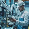 Worker with hard hat in a factory with robotic arms