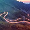 Long exposure of vehicles winding on hilly roads.