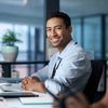 Man working in office smiling while working on computer