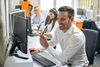 Man smiling while working on computer in office
