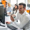 Man smiling while working on computer in office