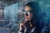 Close up of a woman with glasses while she is working with a computer with holograms. 