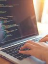 Hands coding at a laptop.