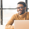 Smiling person in glasses with a laptop