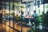 An external view of people sitting in a meeting room through a glass wall.