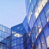 Multistory glass and steel building against a blue sky.