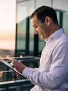 Person accesses an e-book on a tablet outdoors.