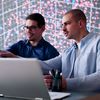 Two businessmen collaborating in front of a laptop