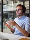 A managed services expert sits at a desk with a headset and collaborates virtually with a customer.
