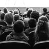 Black-and-white photo of young students in an auditorium.
