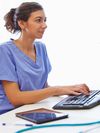 Person sits at a desktop computer with their hands on the keyboard.