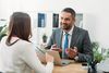 Selective focus of advisor sitting at table with laptop and woman in office
