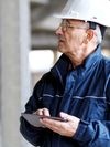 Construction worker wearing a hardhat and holding a tablet.