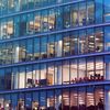 Outside facade of a multistory glass and steel office building.