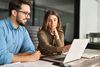 two colleagues looking at the laptop screen to understand automation integration