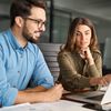 two colleagues looking at the laptop screen to understand automation integration