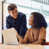 Coworkers having a discussion on AI with laptop in office setting