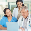 Staff from healthcare industry working in front of laptop together