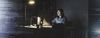 Person sits in a dark office working on their computer.