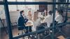 Group of people sit at a conference room in deep discussion.