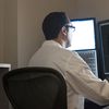 Medical professional reviews medical images on desktop computer screens.
