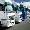 Fleet of large trucks in a parking lot.