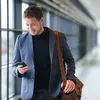 A man is smiling at his phone