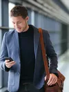 A man is smiling at his phone
