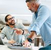 Successful businessmen working together in a co-working office.