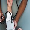 Healthcare professional takes blood pressure of a patient.