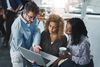 Three technology professionals looking at a laptop