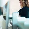 Office worker sitting in front of a desktop computer.