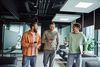 Three male colleagues talking and walking