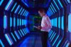 Person in futuristic technology facility looking at digital tablet
