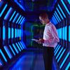 Person in futuristic technology facility looking at digital tablet
