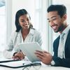 People smiling at tablet in meeting room