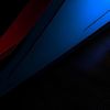 Abstract image with diagonal red and blue shapes over a dark background, featuring subtle gradients and textures.