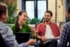 Four smiling office coworkers talking