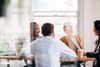 group of 4 people discussing in a meeting