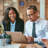 Staff from insurance industry working in front of laptop together