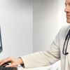 Healthcare professional uses Hyland Healthcare solutions on a desktop computer.