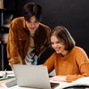 two people discussing and staring at the laptop screen