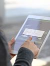 Person holds a digital tablet with a signature block.